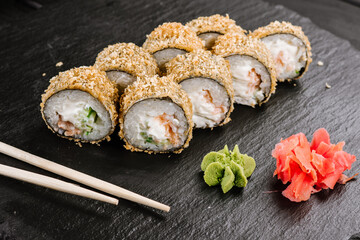 Hot tempura sushi rolls with cream cheese on black background