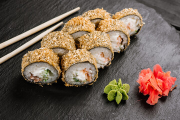 Hot tempura sushi rolls with cream cheese on black background