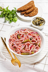 German sausage salad on a white plate, top view
