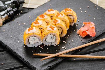 Sushi rolls with cheddar cheese on black background