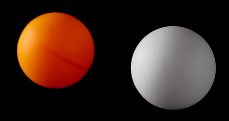 Two ping-pong balls isolated on black background with clipping path