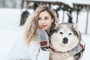 Girl playing with siberian husky in winter forest and park