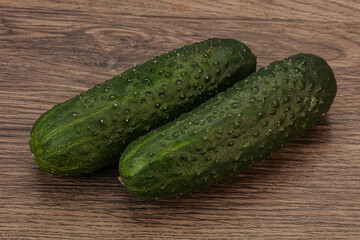 Green fresh cucumbers over background
