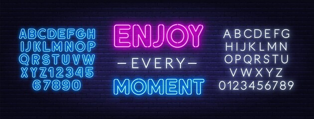 Enjoy every moment neon quote on a brick wall. Inspirational glowing lettering. Neon blue and white alphabet on brick wall background.