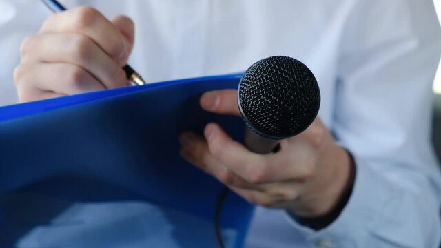 Correspondent or journalist interviewing and writing something down in a notebook