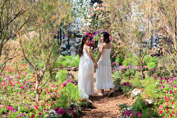 Beautiful Asian couple with with lace wedding LGBT women spent time together in park, homosexual announcement relationship for social acceptance, Attractive 2 women hold hand in hand walking in garden