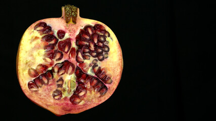 Pomegranate on a black background, close-up. Template for text