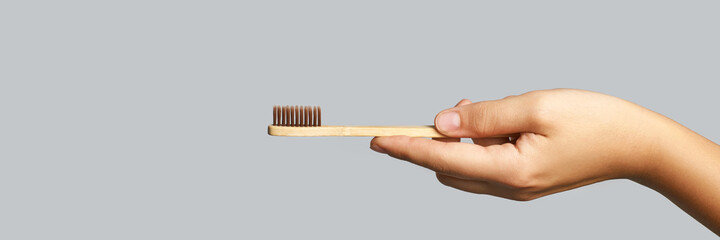 Hand holding toothbrush. Bamboo eco brush. Dental sustainable concept. Layout. Morning home...