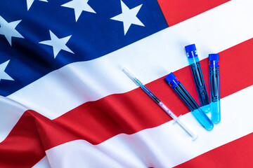 Virus cell usa. Medical syringe with needle for protection flu virus and coronavirus. Covid vaccine on american flag background. Health care in hospital.