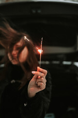 Fototapeta premium Portrait of a woman with sparklers in her hands
