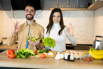 Nice guy and sweet girl with pretty smile are showing that they prefer vegetables to meat to save animals. They look healthy and happy being vegetarian