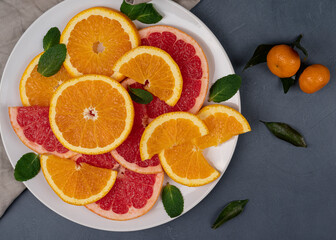 Ripe citrus fruit halved on a white plate, high resolution. Oranges and grapefruit background 