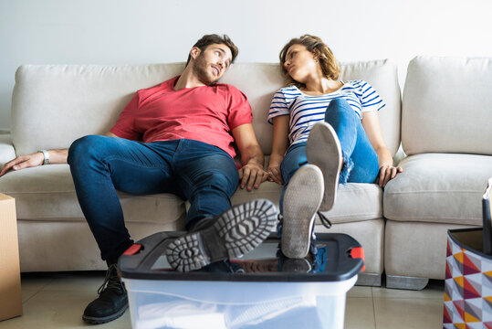 Young couple relaxing on sofa in their new house