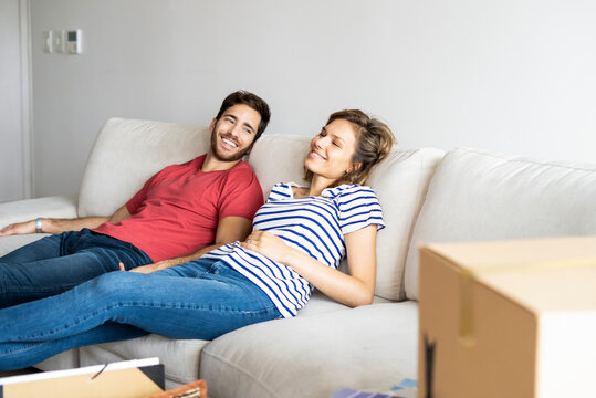 Young couple relaxing on sofa in their new house