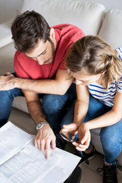 Young couple reading documents in their new house