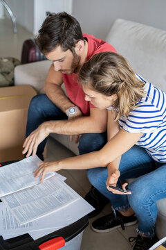 Young couple reading documents in their new house