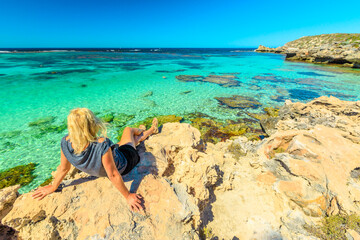 Tourist girl looking turquoise waters of Little Salmon Bay, one of most popular bays on Rottnest Island, Perth, Western Australia. Little Salmon Bay is sheltered, calm and great spot for snorkeling.