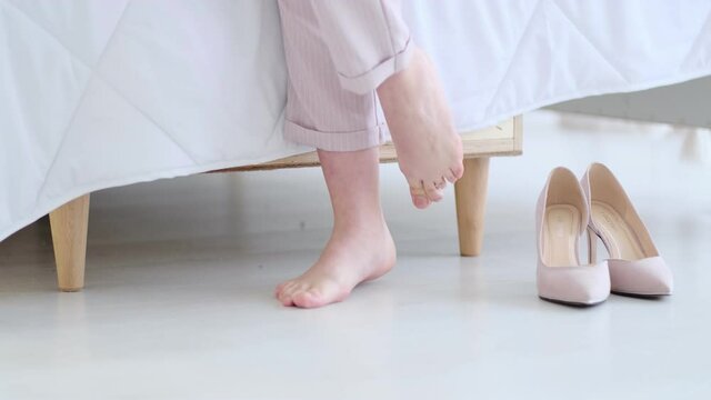 Beautiful young business woman taking her shoes off after a long day. pastel colors, soft focus. Selective focus. Slow motion video. stock footage