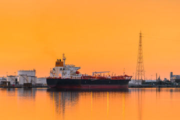 Fototapeta premium Commercial cargo ship at Port Adelaide docks viewed across Port River at sunset