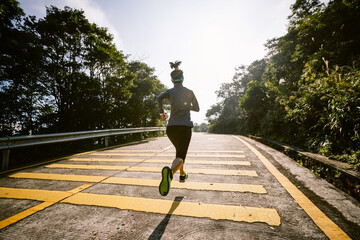 Woman trail runner cross country running in winter mountains