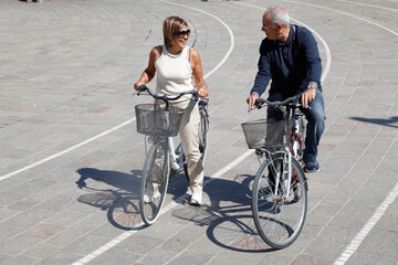 Coppia di anziani in bicicletta si diverte in città 