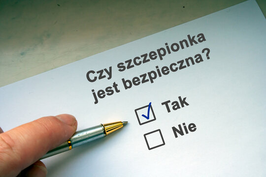 Hand with black pen marking on checklist box. Polish question "Czy szczepionka jest bezpieczna". English: Is the vaccine safe? Coronavirus vaccine