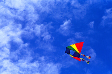 Colourful Kite flying against a blue sky in summer