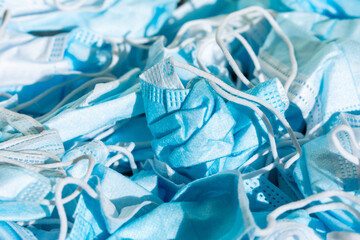 Texture of protective face masks, wrinkled trash, garbage, dirty and discarded, symbol of the health decadence and the global crisis of the COVID-19 pandemic.