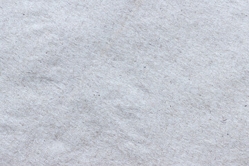 The texture of rough craft paper, interspersed with fibers and particles...