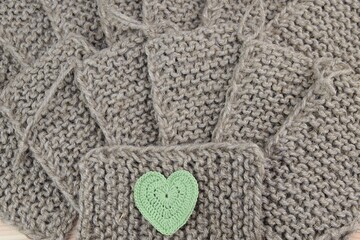 Fototapeta na wymiar Natural jute wahsclothes and green crochet heart for background or texture, zero waste home, love being eco-friendly