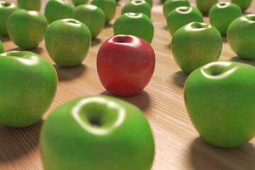A red apple among a group of green apples on wood