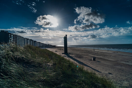 belgium coastline with beautifull sky, city de panne with statue, monument the sun falling on it.  de panne coastline, with beach on it, picture perfect
