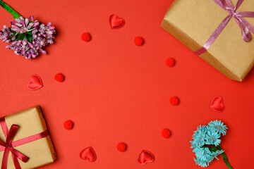 Flat lay. Valentine's Day. Gift boxes, bouquets of flowers, hearts are laid out along the perimeter. Red background.