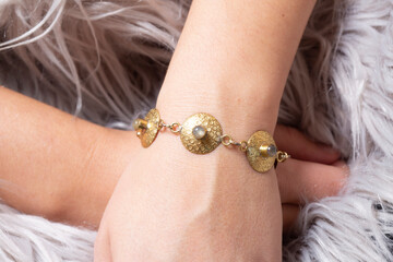 Female hand wrist wearing brass golden bracelet with labradorite mineral stone