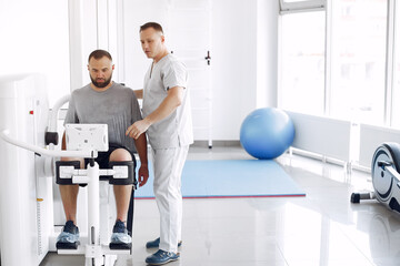 Patient has a rehabilitation in physiotherapy clinic. Doctor in a uniform.