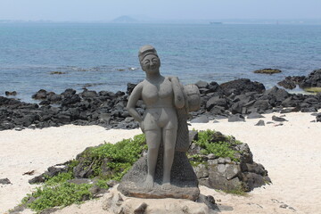 A statue of a haenyeo on the beach of Jeju Island.