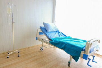  Saline solution hanging near empty  bed in hospital room,Health care concept.