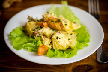 fried omelet with forest mushrooms chanterelles, on table