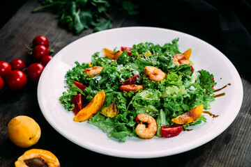 Salad with herbs and shrimps on a white plate