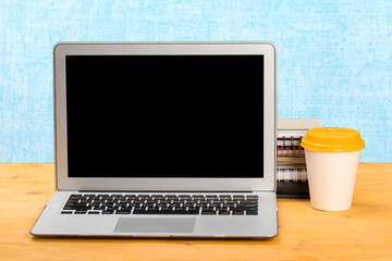 Fototapeta premium mocap Laptop with blank screen for product display and coffee on a wooden table.