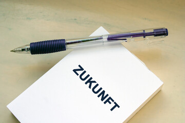 German word zukunft - english is future on paper sheet note with pen. Future