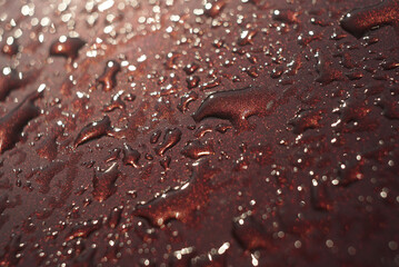 water drops on red shiny surface background