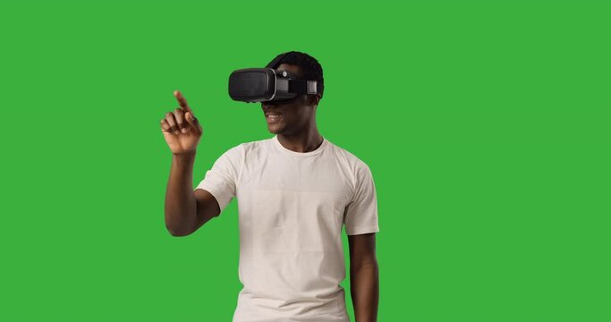 Man wearing vr headset and gesturing over green background