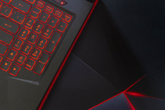 Laptop Keyboard On A Black Background. The Keys Glow Red.