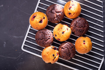 Chocolate and creamy muffins on the kitchen rack. Daylight from the window.