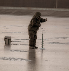 A fisherman catches fish on the ice of the lake