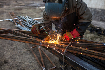 A worker welds metal for a canopy.