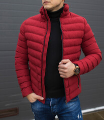 Young handsome guy in a warm knitted clothes against a background of black wall