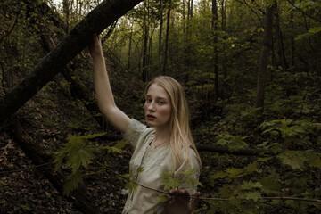 Portrait of a beautiful mysterious woman with blond hair in the forest.  like a fairytale. Warm tone