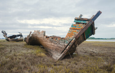 An old wooden shipwreck, showing signs of decay and deterioration. An old nautical sea vessel...
